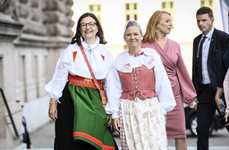 Finansminister Magdalena Andersson och utbildningsminister Anna Ekström iklädda folkdräkt anländer till riksdagshuset.