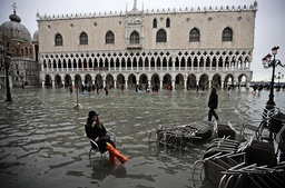 En kvinna har slagit sig ner på en stol vid vattenmassorna på Markusplatsen i Venedig på onsdagen.