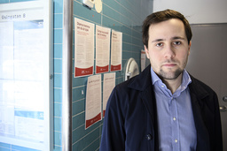 Benjamin Dousa, ordförande i Rinkeby-Kista stadsdelsnämnd, visar informationen om coronaviruset som satts upp i ett trapphus i Husby.