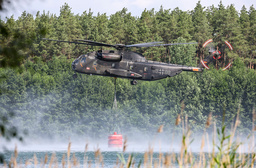 En arméhelikopter som satts in för att bekämpa en brand i Elbe-Elster i Tyskland fyller på vatten.