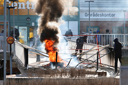 Personer gör en barrikad med brinnande bildäck och andra föremål vid upploppen i Navestad i Norrköping på påskdagen. Arkivbild.