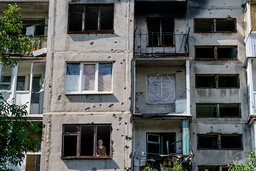En kvinna tittar ut genom ett fönster i Slovjansk i regionen Donetsk.