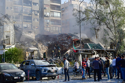 Människor samlas vid en förstörd byggnad vid Irans ambassad där flera högt uppsatta militärer har dött i en flygattack. Bild från attacken 1 april 2024.