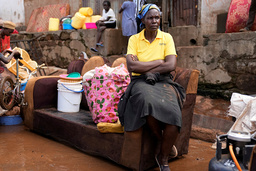 En kvinna sitter på en soffa utanför sitt översvämmade hus i den informella bosättningen Mathare i Kenyas huvudstad Nairobi.