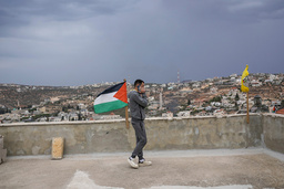 En man med den palestinska flaggan i en by på Västbanken i november 2023.