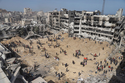 Palestinier går genom förstörelse i närheten av Shifasjukhuset. Bild från i början av april.