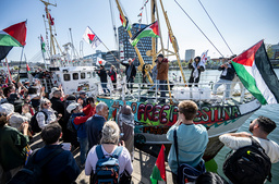 Demonstranter med palestinska flaggor på kajen när Ship to Gaza-skeppet M/S Handala styr in för att lägga till i Malmö.