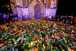 Blommor och ljus utanför en kyrka i närheten av julmarknaden.