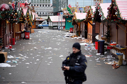 En polis vid den avspärrade julmarknaden i Magdeburg, där flera personer dödades när en bil körde in i en folkmassa på lördagen.