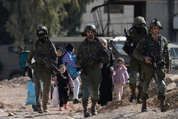 Israeliska soldater går framför palestinier som flyr offensiven i Jenin på torsdagen.