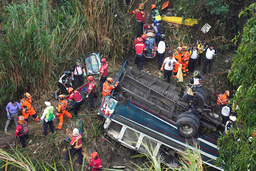 Räddningstjänsten arbetar vid bussen som störtat ned i ravin i Guatemala City.